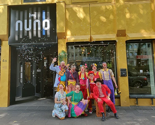 Klinikclowns posieren vor Nuno-Gebäude, umgeben von Seifenblasen